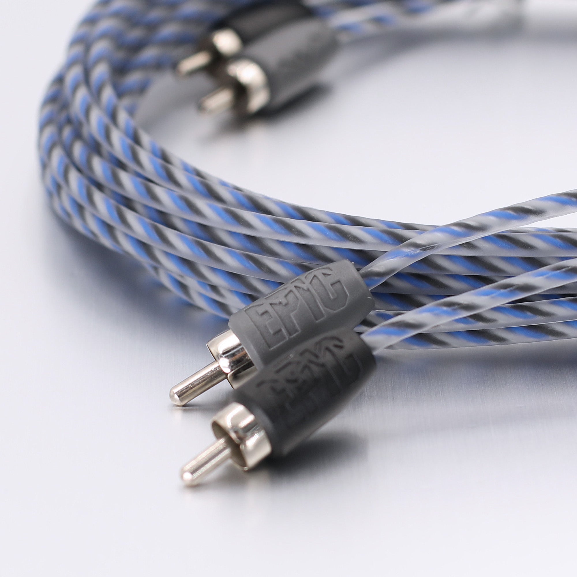 A close-up of a braided audio cable with blue, gray, and white twisted strands, featuring black connectors with silver metal pins and a visible embossed 'ETEC' brand on the connector housing.