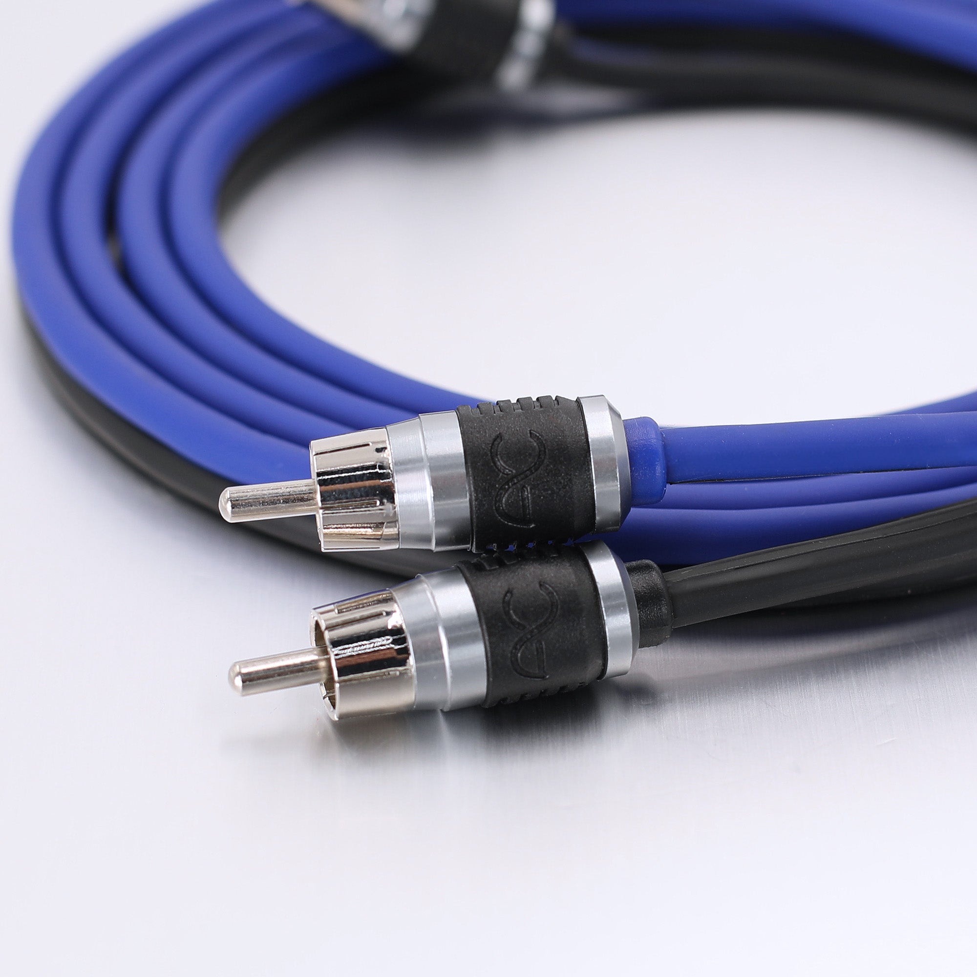 A close-up of a coiled blue and black audio cable with two RCA connectors on a white background.