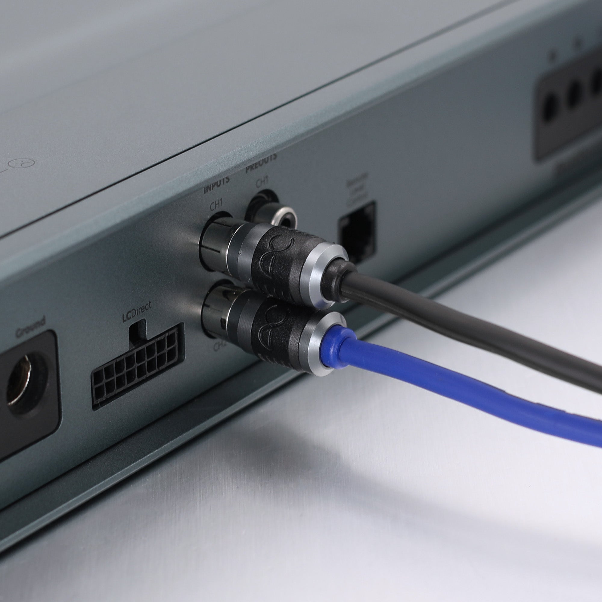 Close-up of audio or video input connectors on a silver electronic device, with a black cable and a blue cable plugged in.