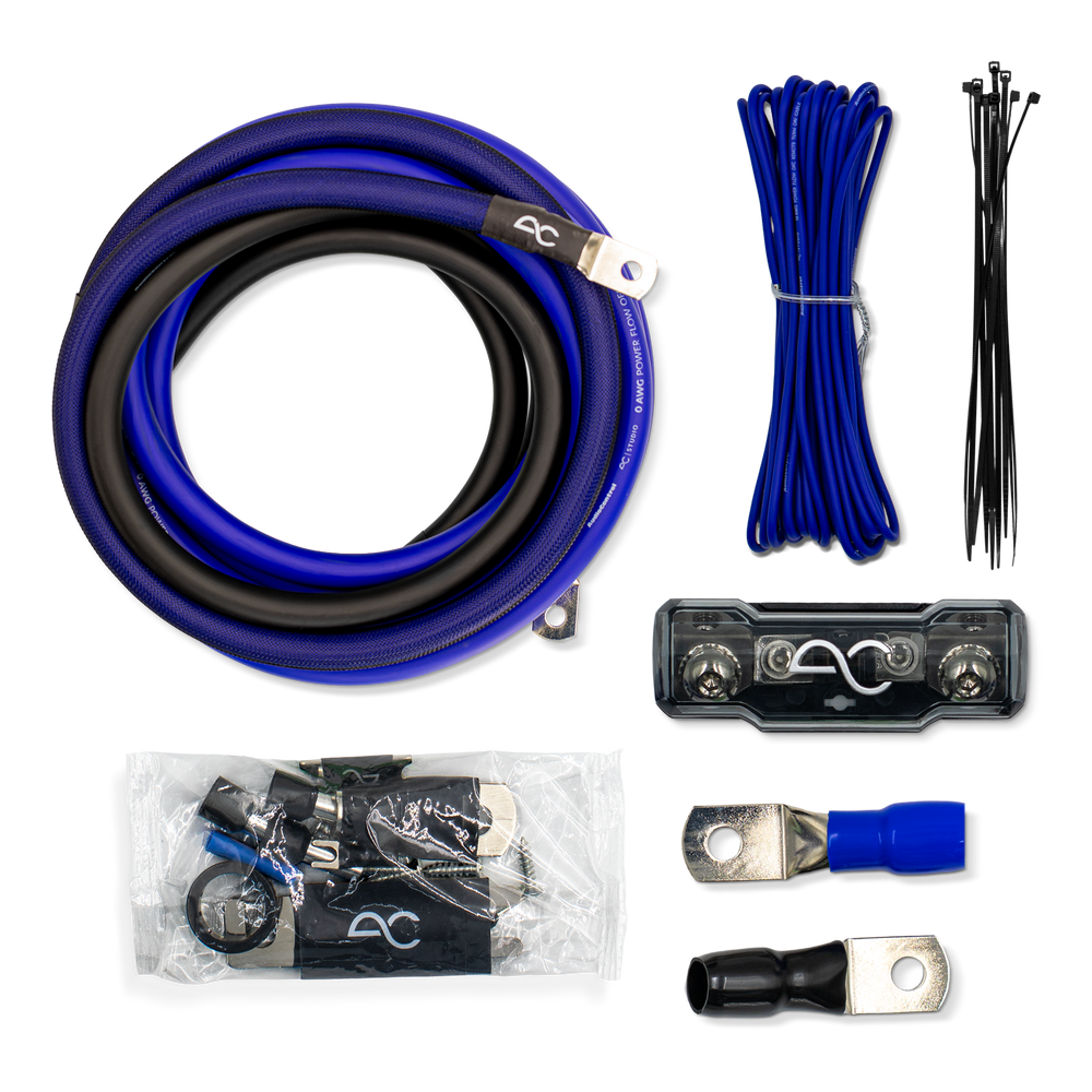 A multi-piece audio power cable kit laid out on a white background, including a coiled blue and black cable, blue wire, black zip ties, a black terminal block, ring splices, and a small accessory package with a branded pouch.