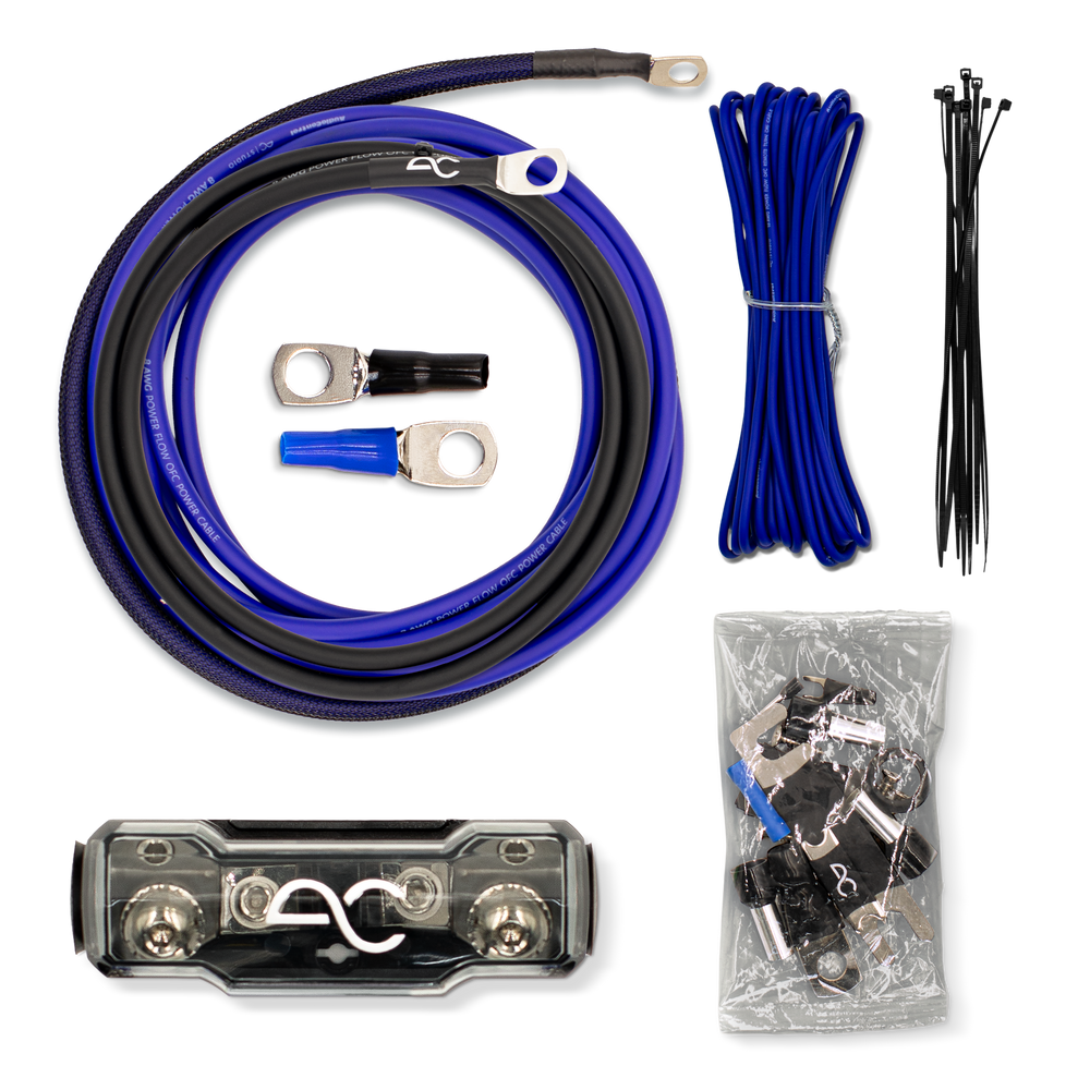 A multi-piece automotive electrical cable kit laid out on a white background, including a large blue and black cable with ring terminals, a bundle of blue cable, black zip ties, a bag of terminal connectors, and a black clamp piece.